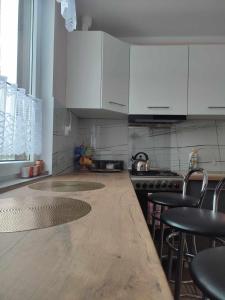 a kitchen with white cabinets and a wooden counter top at Domek Żegary in Sejny