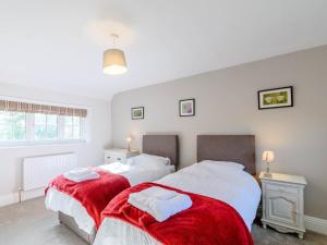 Duas camas num quarto com cobertores vermelhos e brancos em 3 Bed in Kiplin 79275 em Great Langton
