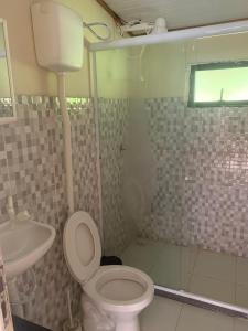 uma casa de banho com um chuveiro, um WC e um lavatório. em Aldeia Gaia Chalés em Teresópolis