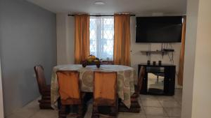 a dining room with a table and a television at Casa Cuenca in Cuenca