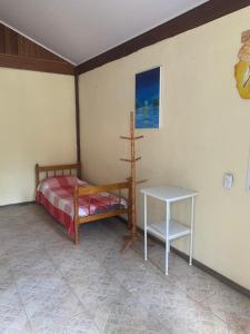 a bedroom with a bed and a table in it at Aldeia Gaia Chalés in Teresópolis