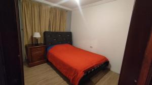 a small bedroom with a bed and a night stand at Casa Cuenca in Cuenca