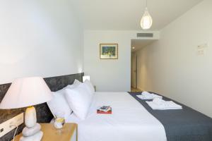 a hotel room with a bed with a lamp and a book at Essential by Charlie in Jávea +22 photos