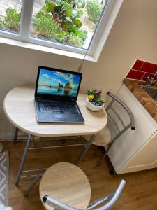 a laptop computer sitting on a table in a kitchen at Self-Contained Double-bed Studio in Central Sherwood in Nottingham