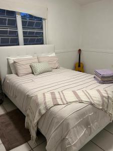 a large bed in a white room with a window at Casa Centrica 