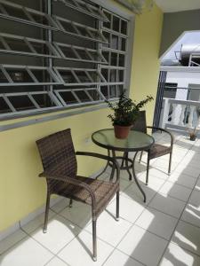 a patio with a table and two chairs and a plant at Casa Centrica 