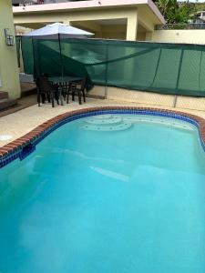 a large blue swimming pool with a table and an umbrella at Casa Centrica 