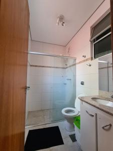 uma casa de banho com um chuveiro, um WC e um lavatório. em Poente Hostel em Belo Horizonte