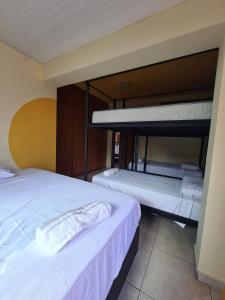 two beds in a room with two bunk beds at Poente Hostel in Belo Horizonte