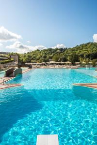 a large swimming pool with blue water at Mulino Di Quercegrossa in Quercegrossa