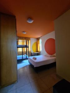 a small bedroom with a bed and a window at Poente Hostel in Belo Horizonte