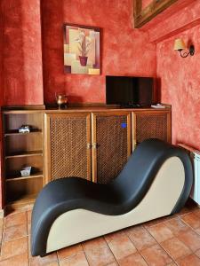 a black and white chair in a room with a tv at El Cerrillo 1 in San Martín del Pimpollar