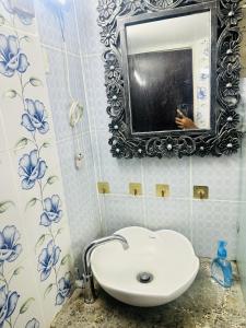 a bathroom with a white sink and a mirror at Beautiful 1-Bed Studio in Dhaka in Dhaka