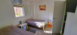 Habitación pequeña con 2 camas y ventana en Posada de Bien, en Herencia