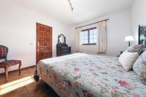 a bedroom with a bed and a chair and a window at Casa Diama in Yaiza
