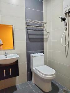 łazienka z toaletą i umywalką w obiekcie Weng Kong Homestay w mieście Slim River