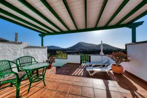 亚伊萨Casa Diama - By Lanzarote Vacation Homes的屋顶上带桌椅的天井