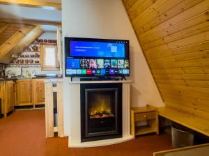 a living room with a fireplace with a tv on top at CHATKA ŠTÔLA in Štôla