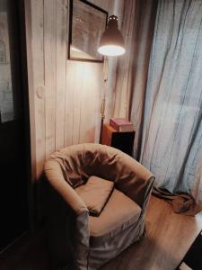 una silla sentada en una habitación con una lámpara en bienvenue chez vous, en Bernières-sur-Mer