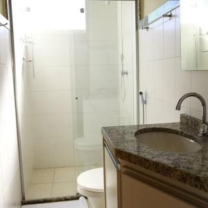 a bathroom with a shower and a sink and a toilet at Rivello Apart Hotel in Sete Lagoas