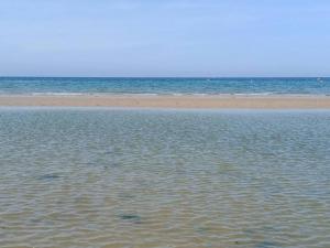 un cuerpo de agua con una playa y el océano en bienvenue chez vous, en Bernières-sur-Mer
