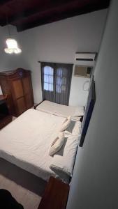 1 dormitorio pequeño con 1 cama con sábanas blancas en Casa funes en Funes