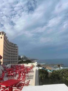 un grupo de mesas y sillas rojas en un balcón en Seasons Court umhlanga 2bed Apt, en Durban