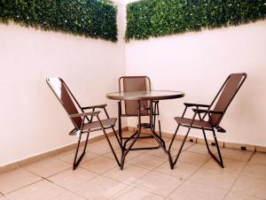 uma mesa e duas cadeiras sentadas ao lado de uma parede em Departamento México em Tampico