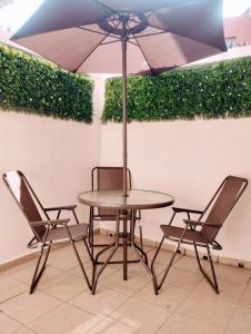a table and two chairs with an umbrella at Departamento México in Tampico