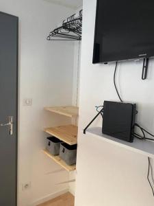 a room with a tv on a white wall at Petit studio centre ville boucle in Besançon