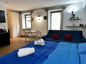 a blue bed with two pairs of white towels on it at Nel Pieno Centro Storico [Tutto a Due Passi] in Casale Monferrato