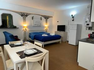 a room with a bed and a table and a kitchen at Nel Pieno Centro Storico [Tutto a Due Passi] in Casale Monferrato