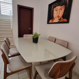 una mesa de comedor blanca con una maceta. en Sobrado privativo com suite, en Sinop