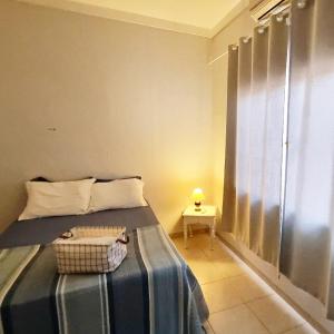 um quarto com uma cama e uma mesa com um candeeiro em Sobrado privativo com suite em Sinop