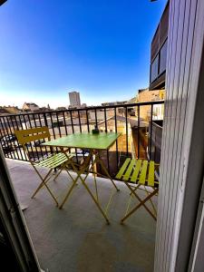 奧爾良的住宿－T2 - L'indispensable，阳台配有一张绿色桌子和两把椅子