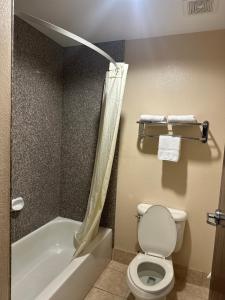 a bathroom with a toilet and a tub and a sink at Belleza Inn & Suites Humble / FM 1960 in Humble