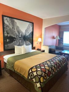 una habitación de hotel con una cama con una gran foto en la pared en Belleza Inn & Suites Humble / FM 1960, en Humble