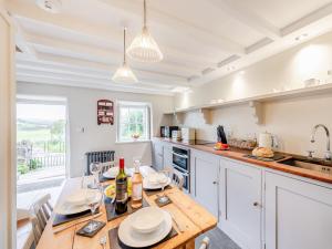 a kitchen with a wooden table with wine bottles on it at 2 Bed in Betws-y-Coed SKN03 in Yspytty-Ifan