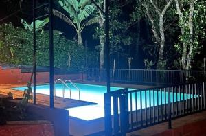 a swimming pool in a park with trees in the background at Peakaavu Cottages in Idukki