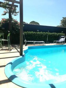 una gran piscina azul con mesa y sillas en Casa Green Piccoli - Itajaí/SC en Itajaí