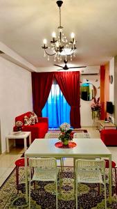 - un salon avec une table et un canapé rouge dans l'établissement AF Homestay 3BR Near KLIA Free Wifi Netflix, à Sepang