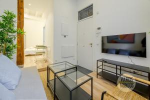 a living room with a couch and a tv at Cool And New Apt 3px entre Gran Via y Palacio Real in Madrid