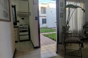 an open door to a kitchen with a stove and a chair at Duplex Centrico/Costanera in Viedma