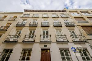 an apartment building with balconies and a wooden door at Cool And New Apt 3px entre Gran Via y Palacio Real in Madrid