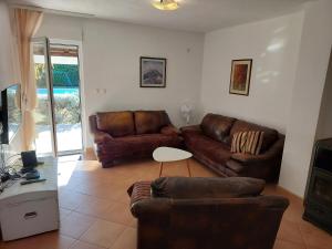 uma sala de estar com dois sofás de couro e uma mesa em Holiday Home Vemini em Mostar
