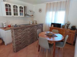 uma cozinha com uma mesa de madeira, uma mesa e cadeiras em Holiday Home Vemini em Mostar
