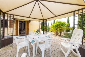 - une table et des chaises blanches sous une tente sur une terrasse dans l'établissement Casa Vacanze Poggio Aprico, à Venturina Terme
