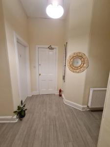an empty hallway with a white door and a potted plant at Cathcart Place Rooms in Edinburgh