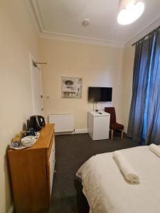 a hotel room with a bed and a desk and a chair at Cathcart Place Rooms in Edinburgh +10 photos
