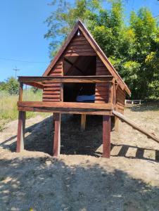 a small wooden dog house with a roof at Pousada 4 estações/chalés in Sapopema